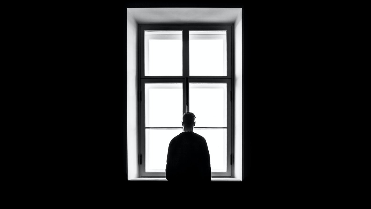Blog image: Back of a man looking out of a window.