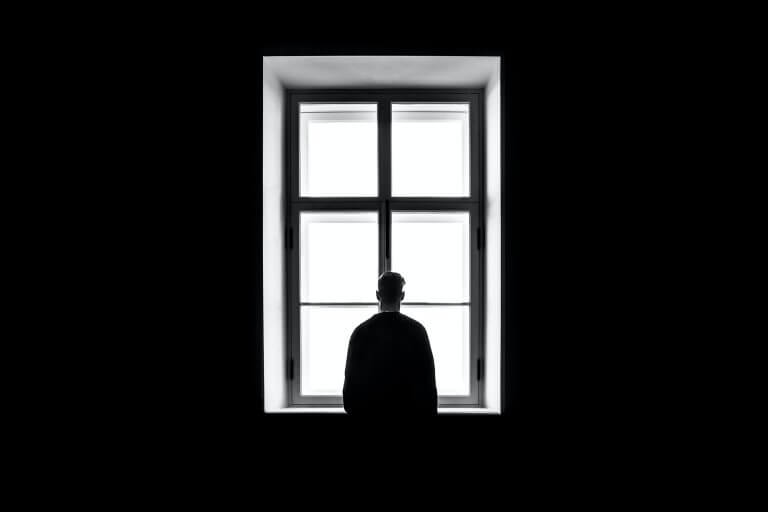 Blog image: Back of a man looking out of a window.