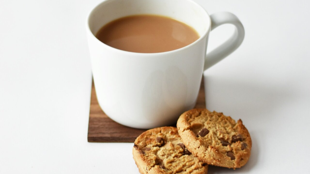 An image of a cup of tea and two cookies laid next to it.