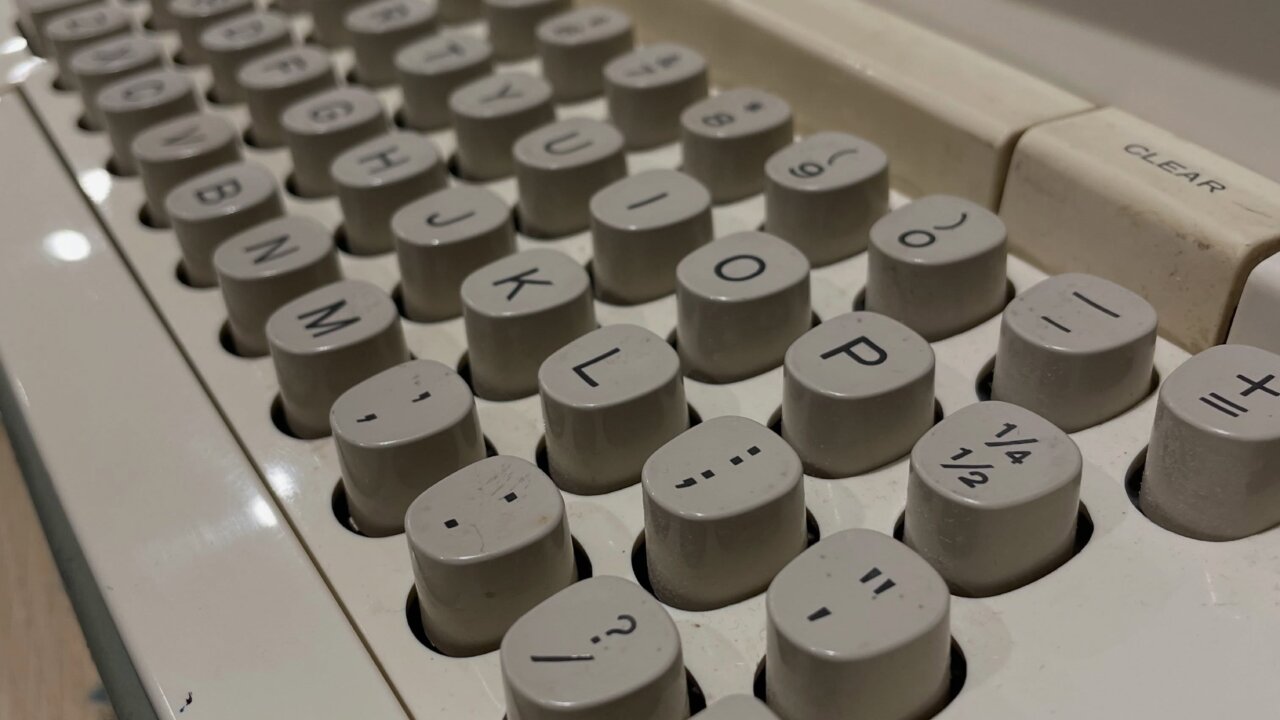 A close up of an electrical mechanical typewriter keyboard. It is from the 60s, a Smith Corona Electra 120 and hows signs of wear and grime.