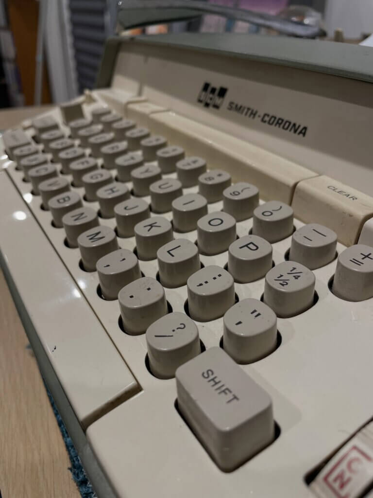 A close up of an electrical mechanical typewriter keyboard. It is from the 60s, a Smith Corona Electra 120 and hows signs of wear and grime.